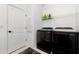 Functional laundry room with black washer and dryer, shelving, and ample storage space at 2930 61St E Dr, Ellenton, FL 34222