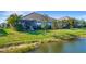 Lush backyard overlooking a pond, featuring a screened-in patio and mature landscaping at 3325 Azurite Way, Bradenton, FL 34211