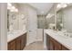 Elegant bathroom with double vanity, dark wood cabinets, decorative mirrors, and a spacious glass-enclosed shower at 3325 Azurite Way, Bradenton, FL 34211