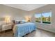 Bedroom with wood-look tile flooring, ceiling fan, and view of the pond at 3325 Azurite Way, Bradenton, FL 34211