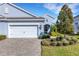 Charming blue single-Gathering home showcasing a well-maintained lawn and a two-car garage with brick driveway at 3325 Azurite Way, Bradenton, FL 34211