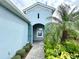 Inviting front entrance with stone path, arched entryway, and lush tropical landscaping at 3325 Azurite Way, Bradenton, FL 34211