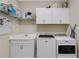 Bright laundry room with white cabinets, shelving, a sink, and Maytag washer and dryer at 3325 Azurite Way, Bradenton, FL 34211