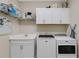 Functional laundry room equipped with modern washer, dryer, sink, and ample storage cabinets at 3325 Azurite Way, Bradenton, FL 34211