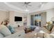 Bright living room featuring a decorative tray ceiling, ceiling fan, and sliding glass doors to the lanai at 3325 Azurite Way, Bradenton, FL 34211