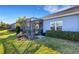 A screened patio with black frames and a brick floor, surrounded by green grass and neatly trimmed shrubs at 3325 Azurite Way, Bradenton, FL 34211