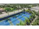 Aerial view of blue tennis courts surrounded by lush greenery, palm trees, and neatly lined streets at 3325 Azurite Way, Bradenton, FL 34211