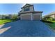 Two-story home featuring a paved driveway and a three-car garage at 4852 Coastal Days Ln, Bradenton, FL 34211