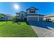 Two-story home boasts a three-car garage, well-manicured lawn, and elegant landscaping at 4852 Coastal Days Ln, Bradenton, FL 34211