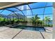 Relaxing screened-in pool with spa, brick pavers, and tropical foliage at 4852 Coastal Days Ln, Bradenton, FL 34211