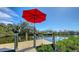 Waterfront dock with red umbrella offering picturesque views of the waterway, perfect for boating and relaxation at 603 Barnes Pkwy, Nokomis, FL 34275