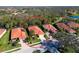 Aerial view of a home with a clay tile roof situated on a verdant, landscaped lot in a scenic residential community at 735 Foggy Morn Ln, Bradenton, FL 34212