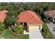 Charming yellow house featuring a well-manicured lawn, lush landscaping, and a red tile roof at 735 Foggy Morn Ln, Bradenton, FL 34212