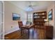 Well-lit office with hardwood floors, built-in shelving, a ceiling fan, and a comfortable leather chair at 735 Foggy Morn Ln, Bradenton, FL 34212