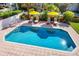 Refreshing swimming pool surrounded by lounge chairs and yellow umbrellas, perfect for leisure at 1023 Tocobaga Ln, Sarasota, FL 34236