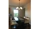 Cozy dining area with modern chandelier, a wooden table with four chairs, and natural light from the window at 15079 Wichita Rd, Port Charlotte, FL 33981