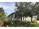 Inviting single-Gathering home with manicured lawn, rock accents, mature trees, and welcoming porch at 15079 Wichita Rd, Port Charlotte, FL 33981