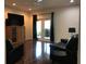 Relaxing living room featuring a ceiling fan, dark leather furniture, and patio access at 15079 Wichita Rd, Port Charlotte, FL 33981
