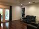 Relaxing living room featuring a ceiling fan, dark leather furniture, and patio access at 15079 Wichita Rd, Port Charlotte, FL 33981