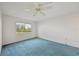 A bedroom with blue carpet, a window, and a ceiling fan at 250 Santa Maria St # 120, Venice, FL 34285