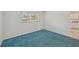 A spare bedroom featuring blue carpeting and large window with blinds at 250 Santa Maria St # 120, Venice, FL 34285