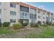 Condominium building featuring manicured landscaping and large windows at 250 Santa Maria St # 120, Venice, FL 34285