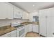 A kitchen with granite countertops, white cabinetry, and stainless-steel appliances at 250 Santa Maria St # 120, Venice, FL 34285