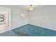 A sparsely decorated room with blue carpeting and a view of the kitchen at 250 Santa Maria St # 120, Venice, FL 34285