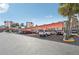 Wide view of neighborhood parking lot on a sunny day with tall palm trees at 250 Santa Maria St # 120, Venice, FL 34285