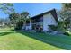 Two-story home with large windows, surrounded by lush greenery and a manicured lawn at 3500 El Conquistador Pkwy # 119, Bradenton, FL 34210
