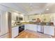 Well-lit kitchen featuring stainless steel appliances, white cabinets, and wood flooring at 3500 El Conquistador Pkwy # 119, Bradenton, FL 34210