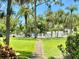Lush walkway leading to a communal pool surrounded by tropical landscaping and lounge chairs at 3500 El Conquistador Pkwy # 119, Bradenton, FL 34210