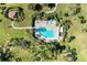 Aerial view of a community pool and hot tub with lounge seating and mature landscaping at 3500 El Conquistador Pkwy # 119, Bradenton, FL 34210
