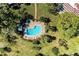 Overhead shot of a private backyard pool with a patio, lounge chairs, hot tub, and tropical landscaping at 3500 El Conquistador Pkwy # 119, Bradenton, FL 34210
