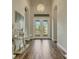 Elegant foyer featuring high ceilings, a chandelier, wood-look tile flooring, and decorative glass doors at 5341 Greenbrook Dr, Sarasota, FL 34238