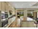 Bright, modern kitchen with stainless steel appliances, a central island, and views of the outdoor patio at 5341 Greenbrook Dr, Sarasota, FL 34238