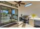 Covered outdoor kitchen features stainless steel grill, mini fridge, granite countertops, and view of the home's interior at 5341 Greenbrook Dr, Sarasota, FL 34238