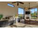 Screened outdoor living area features a built-in grill, fireplace, flat screen television, and an outdoor view at 5341 Greenbrook Dr, Sarasota, FL 34238