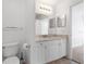Well-lit bathroom featuring a granite vanity, dual mirrors, and white cabinets at 5711 Soldier Cir # 204, Sarasota, FL 34233