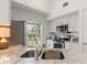 Bright kitchen with white cabinets, stainless steel appliances, granite countertops, and a window view at 5711 Soldier Cir # 204, Sarasota, FL 34233