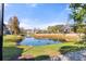 A picturesque view of the pond in the community, with lush landscaping and vibrant colors, reflecting the clear blue sky at 5711 Soldier Cir # 204, Sarasota, FL 34233