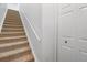 Carpeted staircase with a handrail, providing access to the upper levels of the home at 5711 Soldier Cir # 204, Sarasota, FL 34233