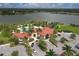 Aerial view of community center showcasing a pool, clubhouse, parking, and nearby lake at 6428 Devesta Loop, Palmetto, FL 34221