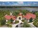 Overhead view of a community clubhouse with a red tile roof near a shimmering lake and lush greenery at 6428 Devesta Loop, Palmetto, FL 34221