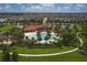 Aerial view of community pool, palm trees, lush landscaping, and surrounding homes at 6428 Devesta Loop, Palmetto, FL 34221