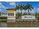 Elegant community entrance sign with a water feature, set against a backdrop of palm trees and blue skies at 6428 Devesta Loop, Palmetto, FL 34221