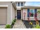 Charming front entrance with a blue door, brick pathway, and colorful plants set against a neutral-toned home exterior at 6428 Devesta Loop, Palmetto, FL 34221