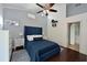 Stylish primary bedroom with a blue upholstered headboard, tray ceiling, and en-suite bathroom at 6589 Fairway Gardens Dr # 202, Bradenton, FL 34203