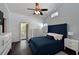 Stylish primary bedroom with a blue upholstered headboard, tray ceiling, and balcony access at 6589 Fairway Gardens Dr # 202, Bradenton, FL 34203