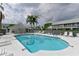 Community pool with lounge chairs, tall palms, and a covered cabana area at 6589 Fairway Gardens Dr # 202, Bradenton, FL 34203